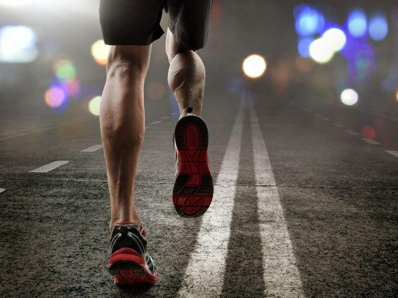 Biegacz biegnie wieczorem po ulicy